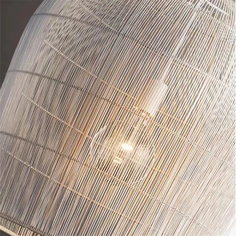 Detailed view of LUXELY white rattan pendant light with exposed bulb, highlighting its minimalist and airy design.