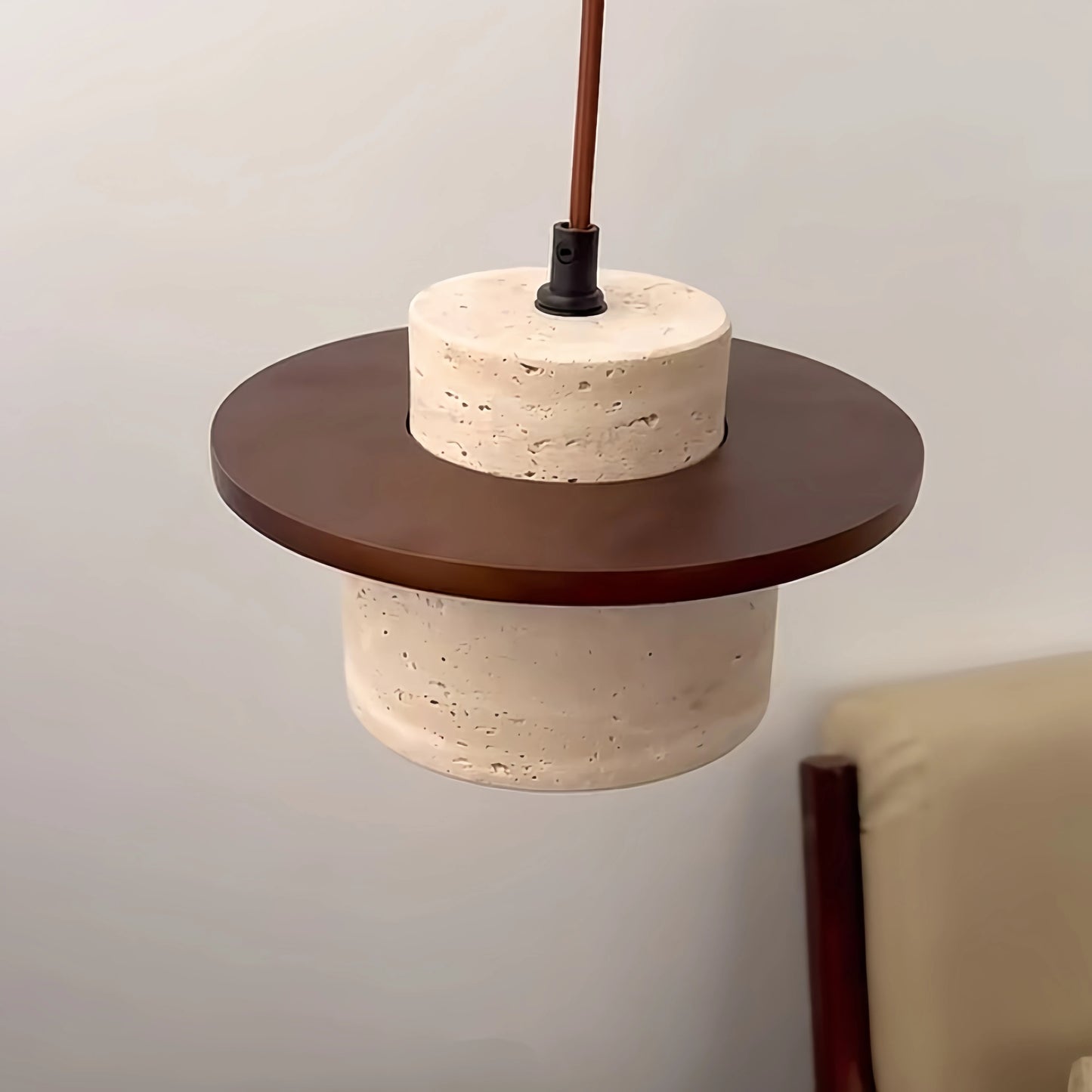 Close-up of LUXELY travertine pendant lamp with dark wood disc, showcasing Japanese minimalist design for home lighting fixtures.