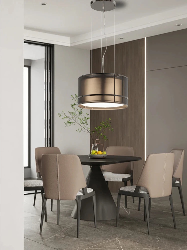 Elegant modern ceiling chandelier by Italian designers above a round dining table with beige chairs in a contemporary dining room.