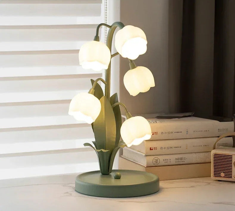 Nordic Atmosphere LED Table Lamp on a desk with books, combining floral elegance with functional lighting for home decor.
