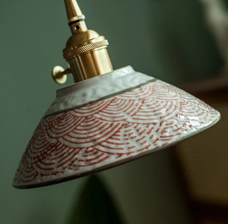 Vintage ceramic pendant lamp with red wave design and LED bulb, suspended in a stylish green-toned room.