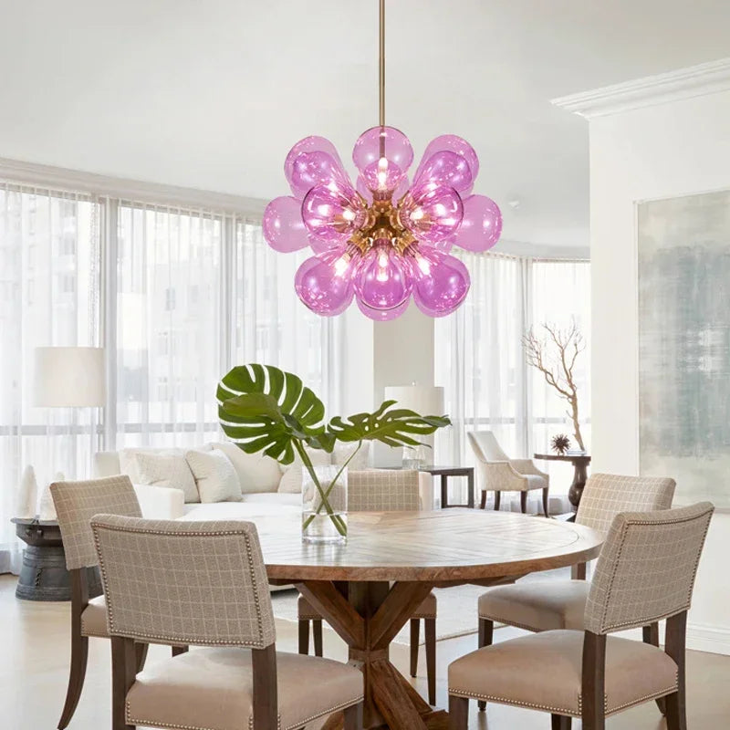Purple Scandinavian glass chandelier with gold lampbody, adding a vibrant touch to a bright, modern dining room.