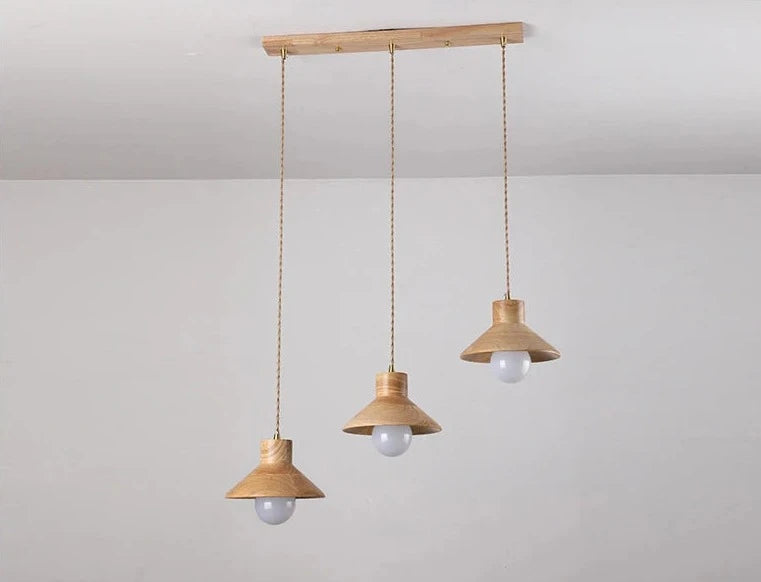 Three Nordic wood pendant lights suspended from wooden ceiling mount, perfect for modern kitchen or dining room lighting.