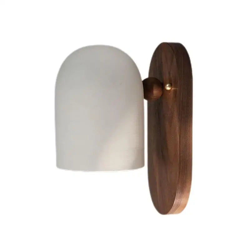Close-up of walnut wood designer sconce with white dome shade, ideal for modern bedroom or office wall lighting.