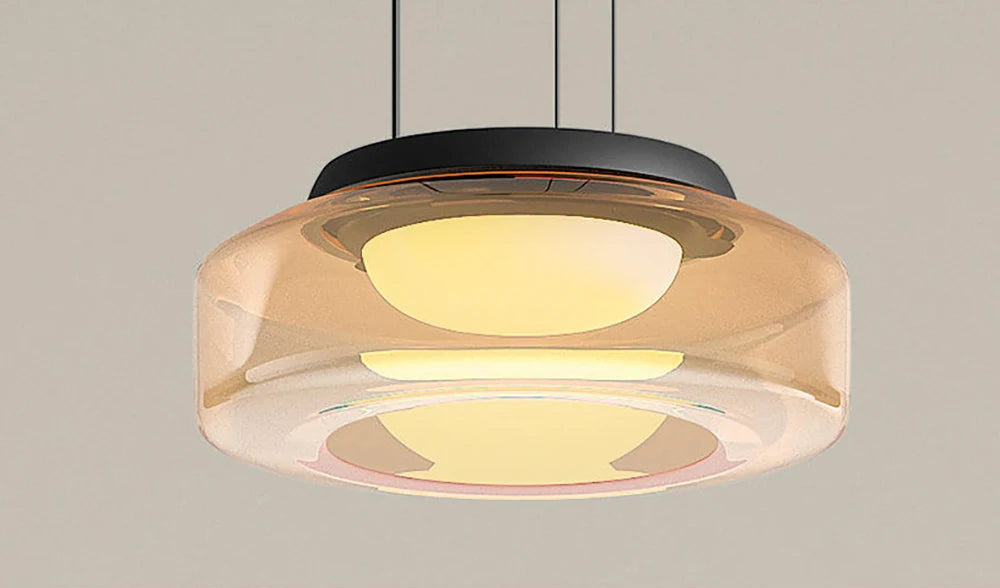 Close-up of amber glass pendant light with LED source. Highlights the warm glow and modern design for kitchen or dining use.
