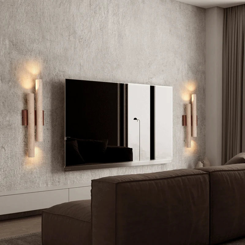 Pair of travertine stone bedroom wall lamps with wood accents flanking a TV, providing soft ambient lighting in a contemporary living room.