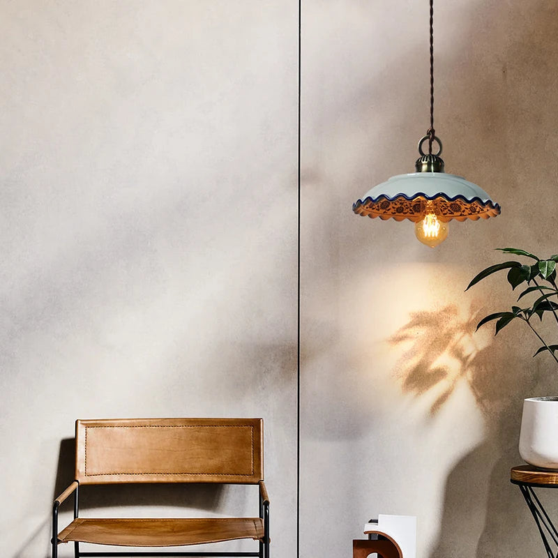 Single ceramic LED pendant lamp with scalloped edge and warm light, enhancing rustic charm in a minimalist living space.