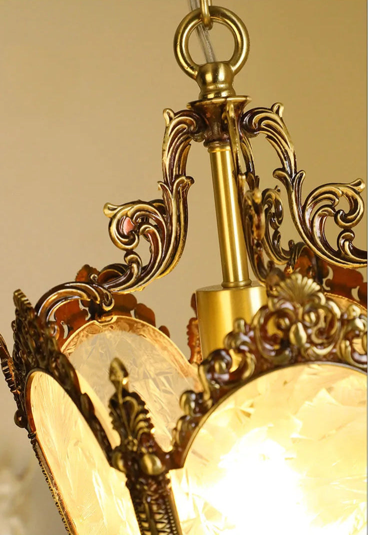Close-up of illuminated French retro chandelier with copper detailing. Elegant pendant light for vintage-inspired interiors.