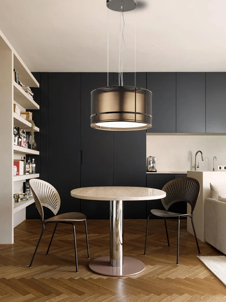 Compact Italian designer chandelier above a small round dining table in a modern kitchen with black cabinetry.