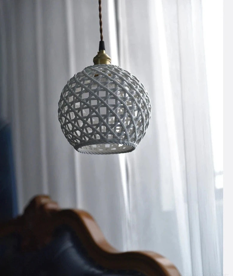 White spherical LUXELY ceramic pendant light hanging near window, blending traditional Japanese design with modern elegance.