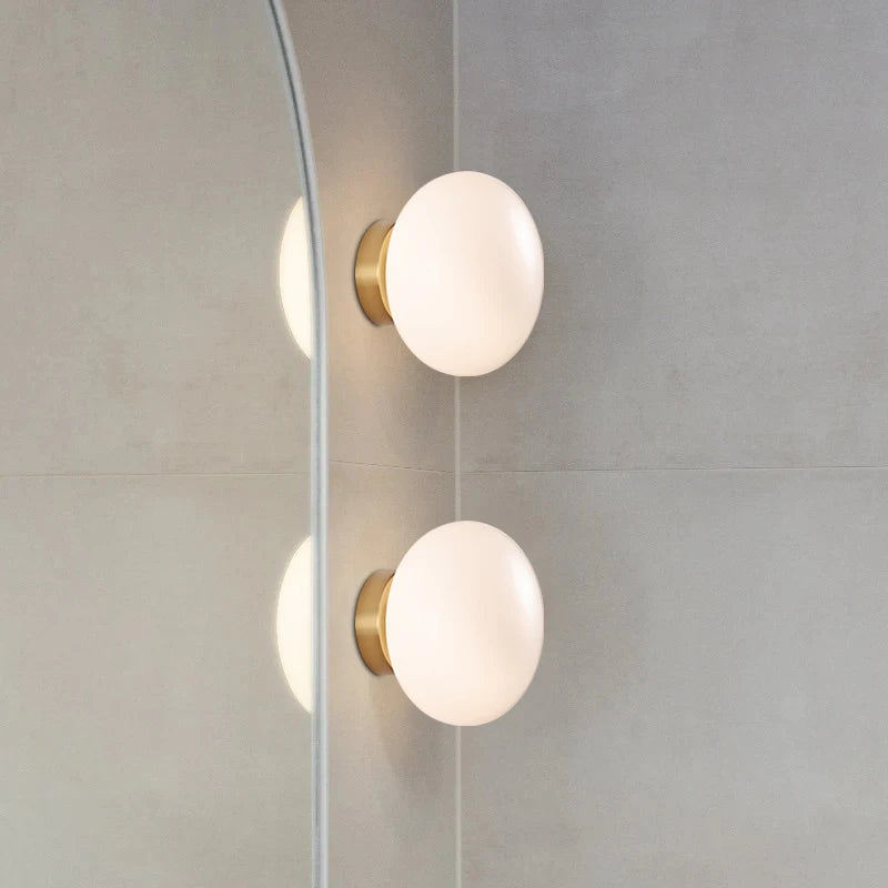 Modern ceiling and wall lights by LUXELY installed in a bathroom setting, showcasing brass accents and soft LED glow for elegant ambiance.