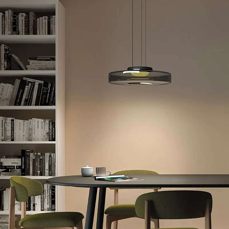 Smoke grey glass pendant light with LED above a dining table. Elegant and dimmable, perfect for kitchen or reading nook lighting.