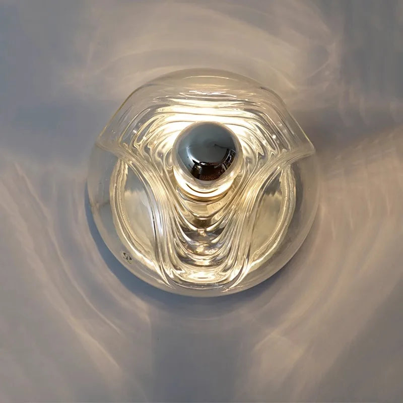 Top view of round LED glass wall lamp emitting soft light, ideal for modern kitchen or dining room decor.