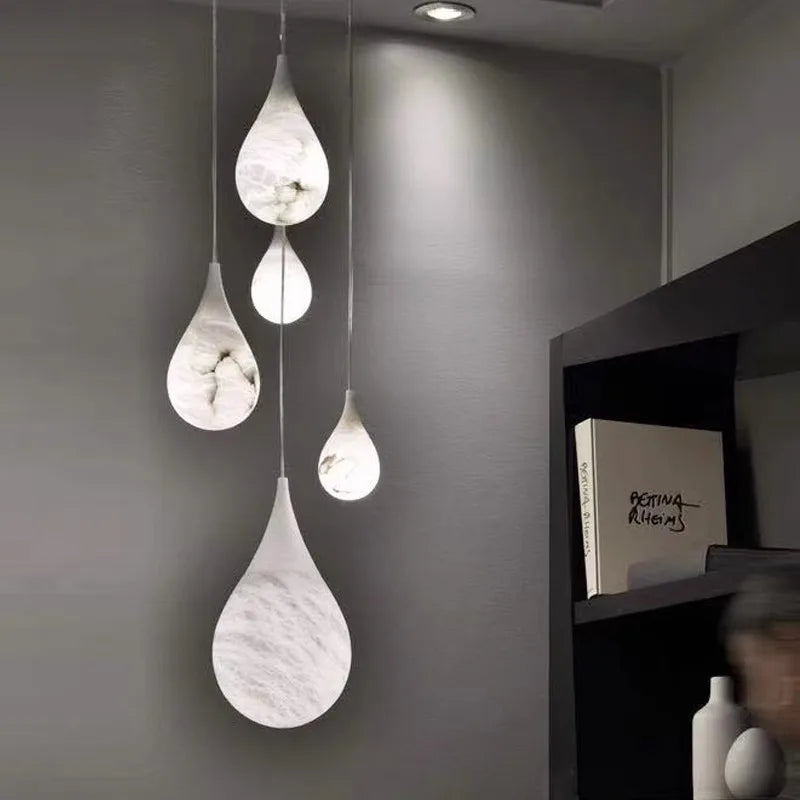 Teardrop-shaped marble LED pendant lights hanging in a modern room. Marble LED pendant light – modern ceiling lamp dimmable for ambient lighting.