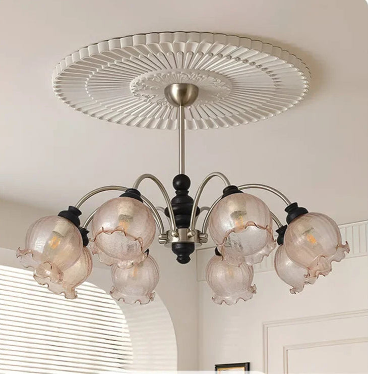 Close-up of American crystal chandelier with LED bulbs and ruffled glass shades, showcasing its elegant black and gold structure.