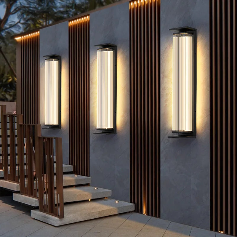 Three stainless steel waterproof wall lamps lighting a contemporary outdoor staircase and fence area.
