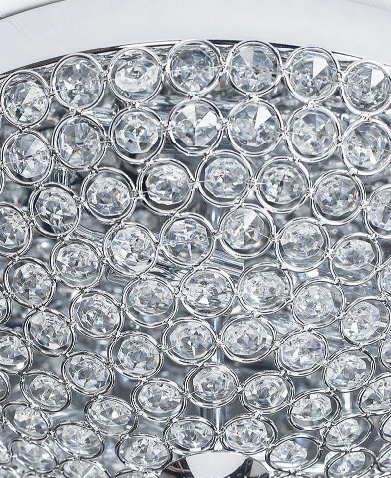 Macro shot of crystal ceiling light's silver frame and clear faceted crystals for a modern luxury look.