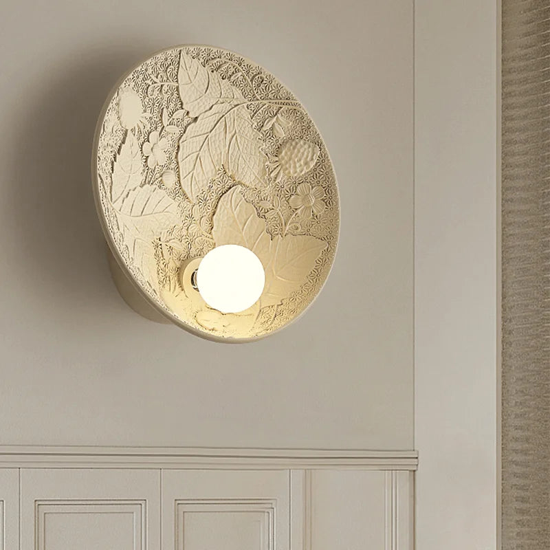 French imperial round wall lamp mounted in a classic interior, featuring detailed floral carvings and soft ambient lighting.