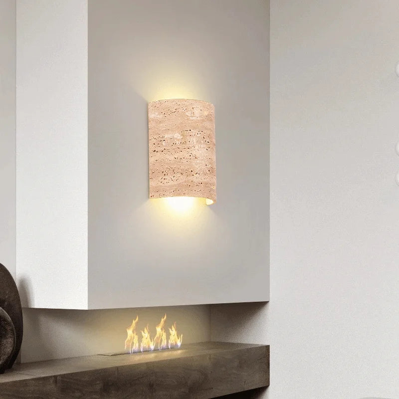 Travertine wall lamp IP65 mounted above a fireplace, blending wabi-sabi aesthetics with functional stone lighting.