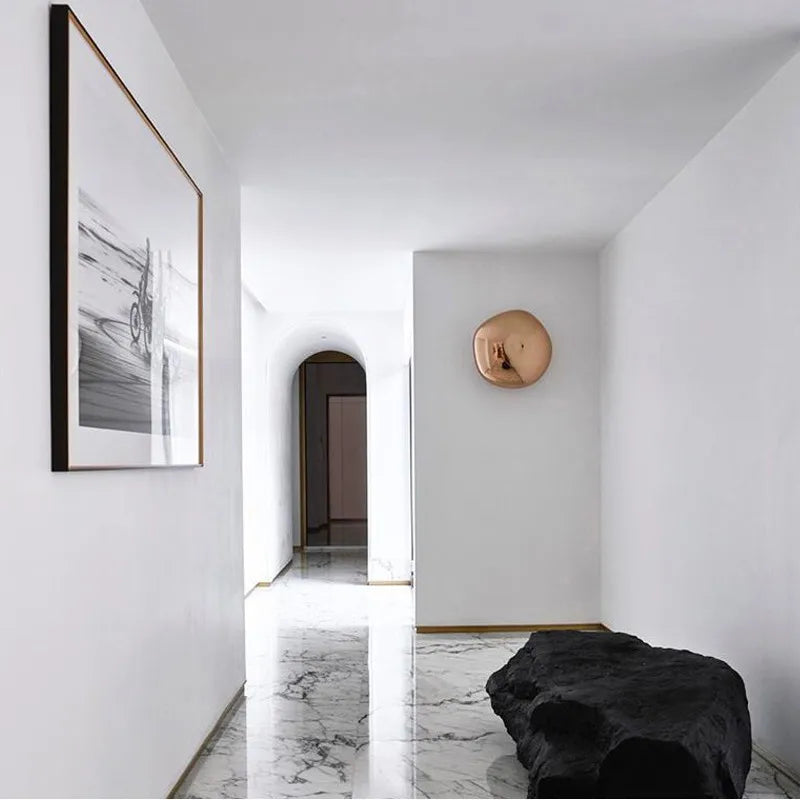 Copper art deco wall lamp mounted in a minimalist hallway, enhancing modern interior lighting aesthetics.