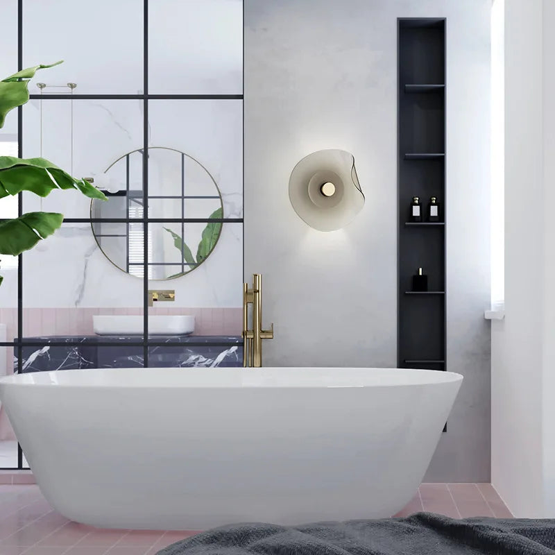 Glass modern wall lamp with sculptural round design illuminating a modern bathroom, enhancing decor with soft ambient lighting.