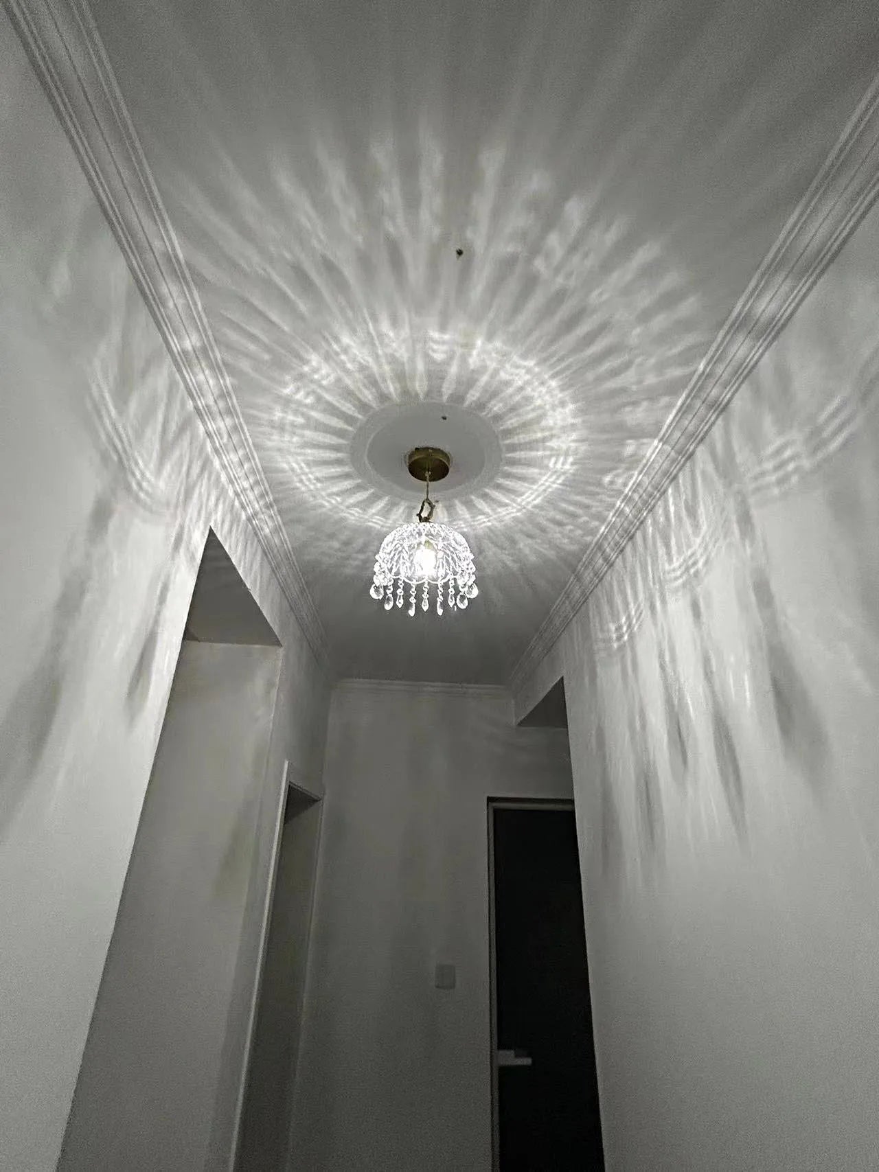 French Vintage Crystal Chandelier - Copper Hanging Lamp casting dramatic radial light reflections on ceiling.