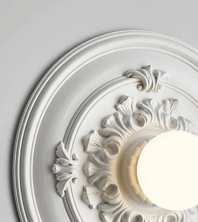 Detailed view of LUXELY white round wall lamp with floral carvings, highlighting its retro aesthetic and soft glow.