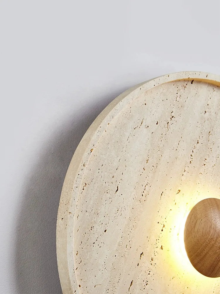 Close-up of LUXELY Japanese wall lamp showing textured travertine stone and soft LED glow from wooden center.