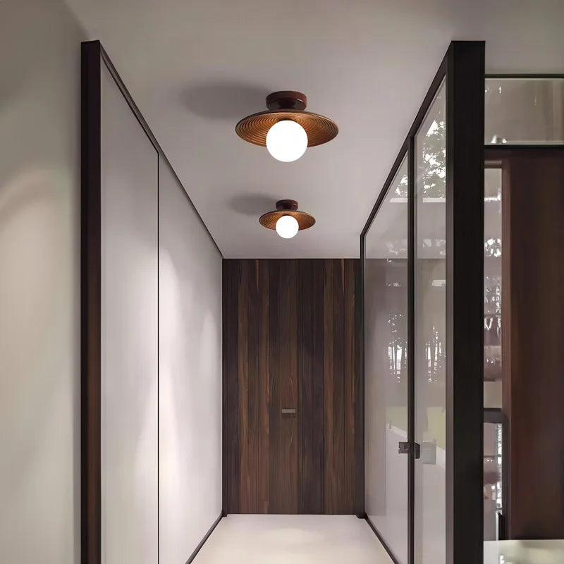Wood flush mount ceiling lights with brass accents installed in a modern corridor, offering warm lighting and minimalist design.