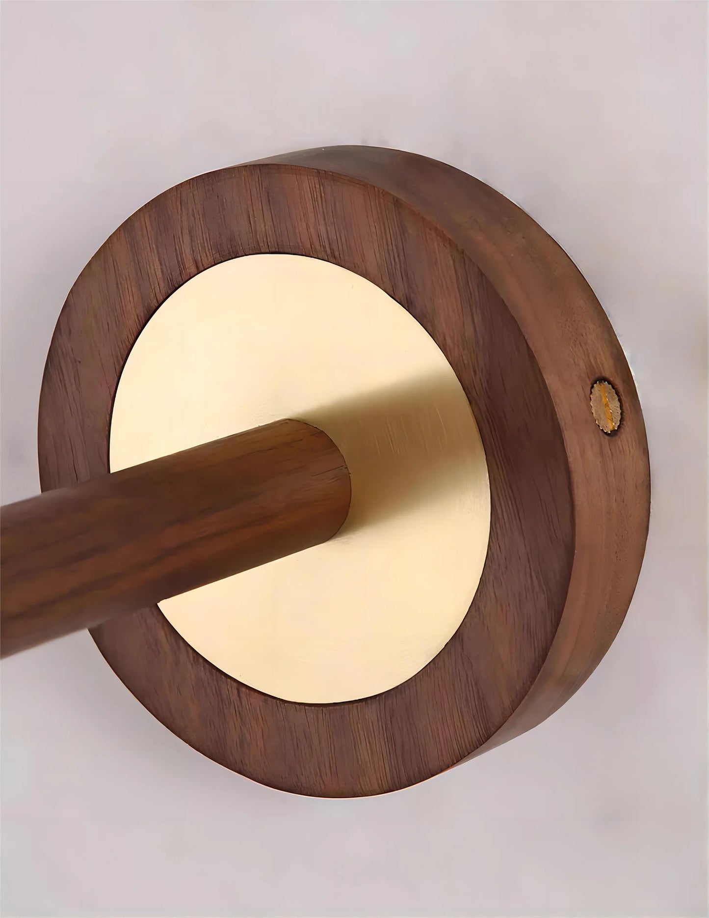 Close-up of brass and wood wall sconce base, highlighting premium materials and craftsmanship in lighting design.
