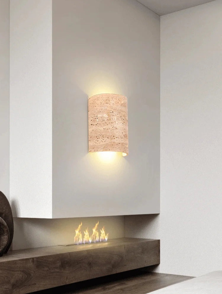 Travertine wall lamp IP65 above modern fireplace, offering ambient lighting with natural stone elegance.