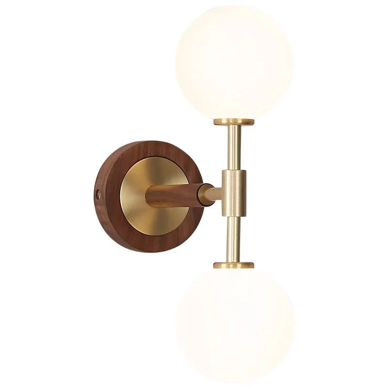 Close-up of LUXELY brass wall sconce showing wood and copper finish with frosted glass globes for stylish lighting.