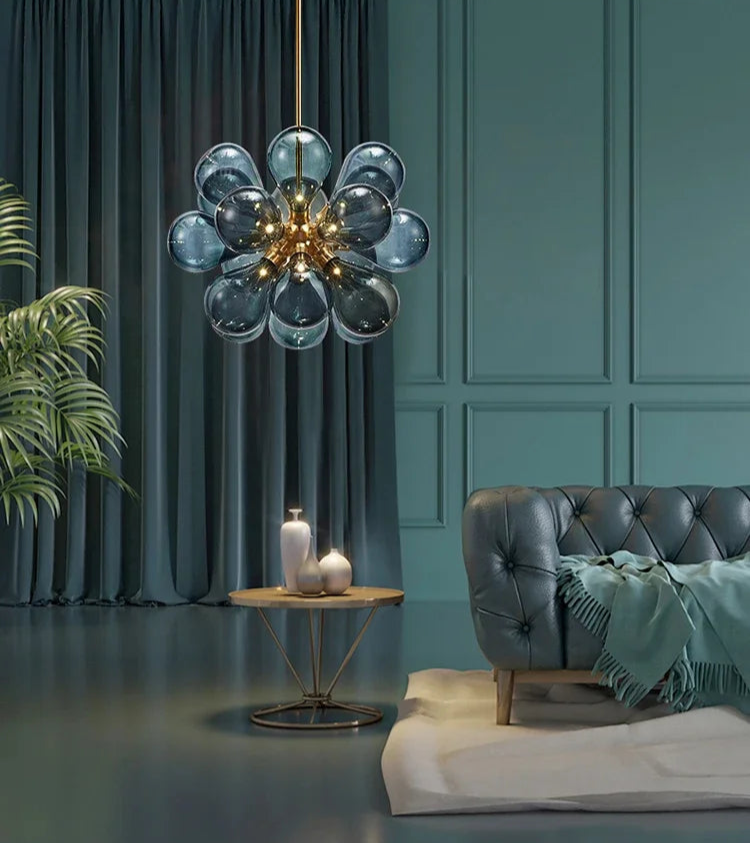 Blue Scandinavian glass chandelier with gold finish, featured in a luxurious bedroom with modern decor.