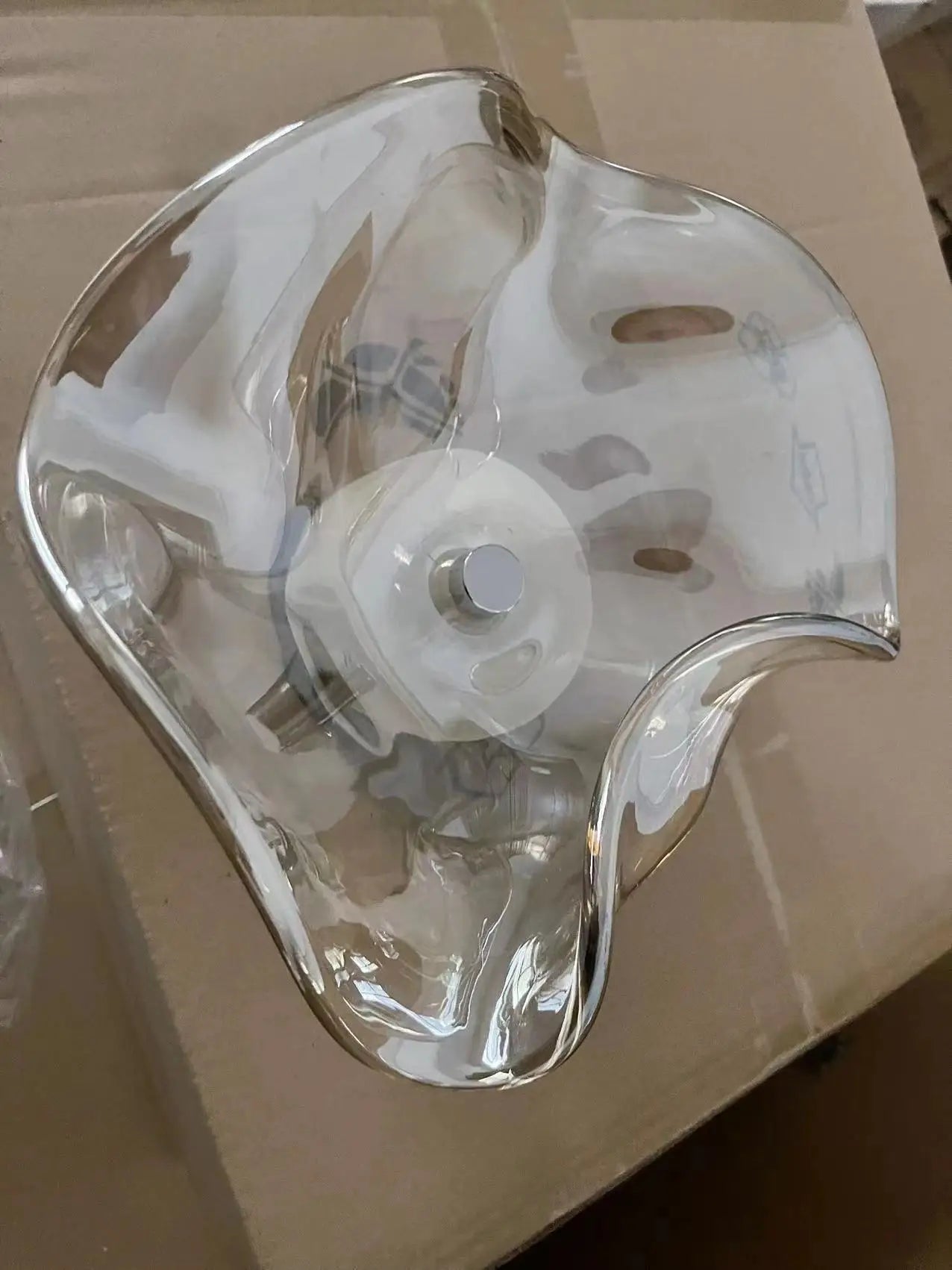 Clear glass modern wall lamp with organic round shape, perfect for contemporary lighting in home or commercial spaces.
