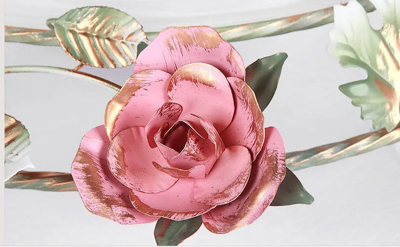 Detailed view of pink rose ornament on romantic chandelier. Hand-painted floral accent enhances French rose ceiling light.