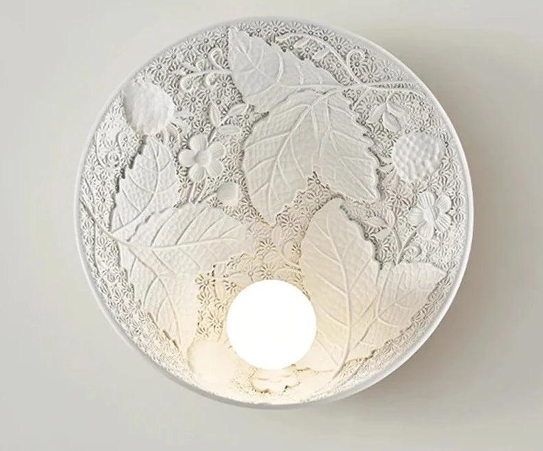 White vintage imperial wall lamp with intricate botanical design, round sconce for modern classic interiors and hotel lighting.