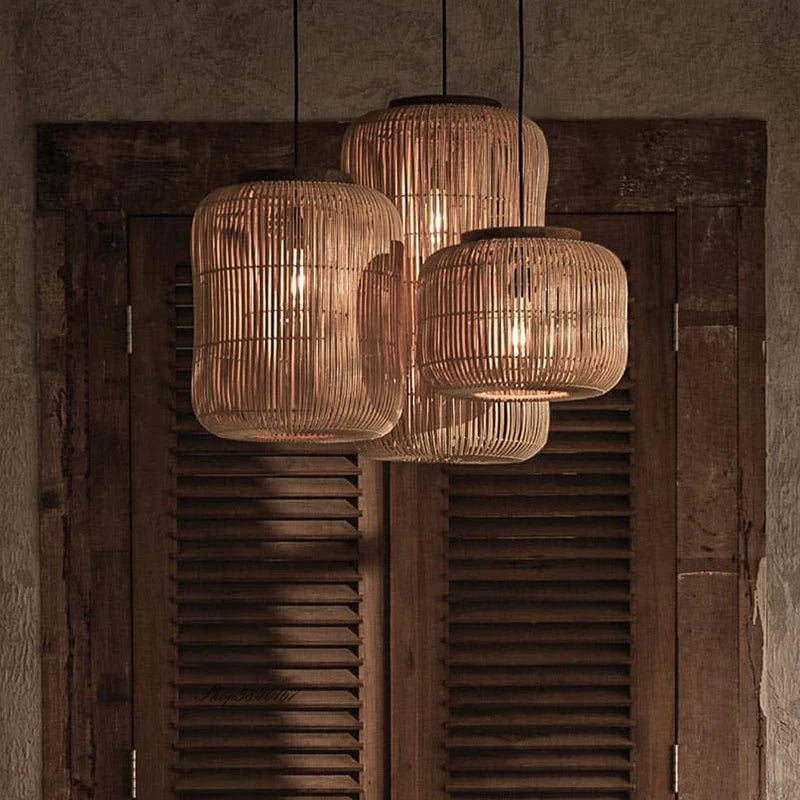 Warm-lit LUXELY retro rattan pendant lights in natural finish, hanging in a rustic japandi interior with wooden shutters.