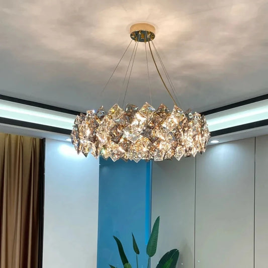 Modern crystal chandelier in gold with LED lighting, suspended in a contemporary living room. Features wide voltage support and luxury design.