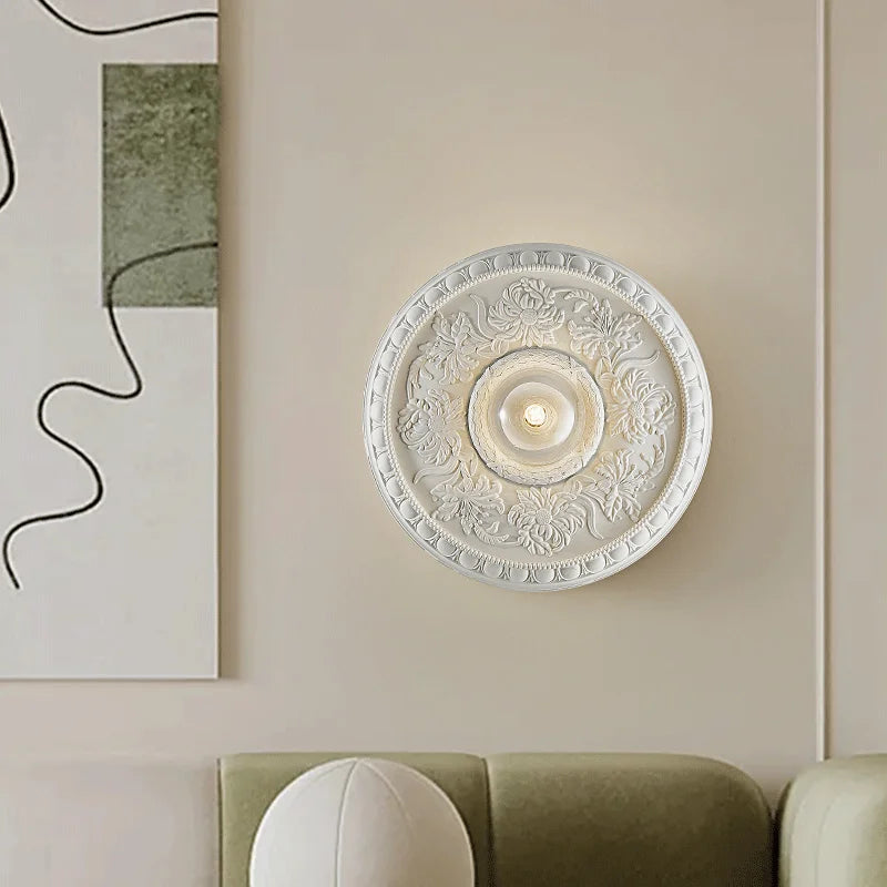 White retro round wall lamp with floral carvings, enhancing a modern living room with refined French-inspired lighting.