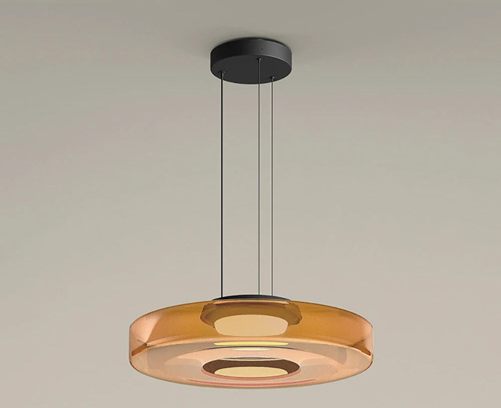 Amber glass pendant light with 45cm diameter and 11cm height. LED light source and adjustable hanging wire for modern interiors.