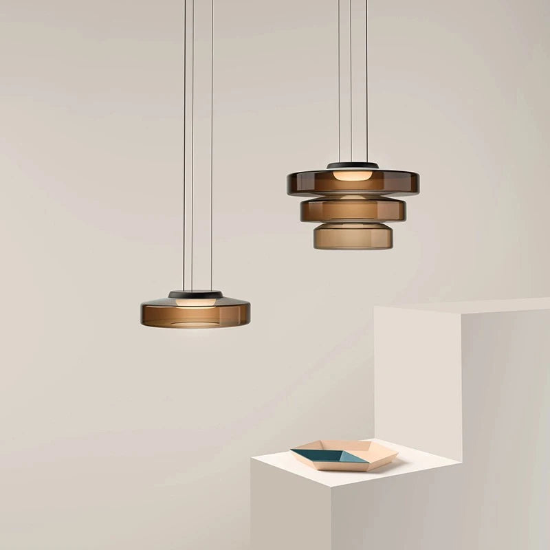 Set of three luxury glass pendant lights in amber, two-tier and single-tier styles. Perfect for modern kitchen or dining room ambiance.