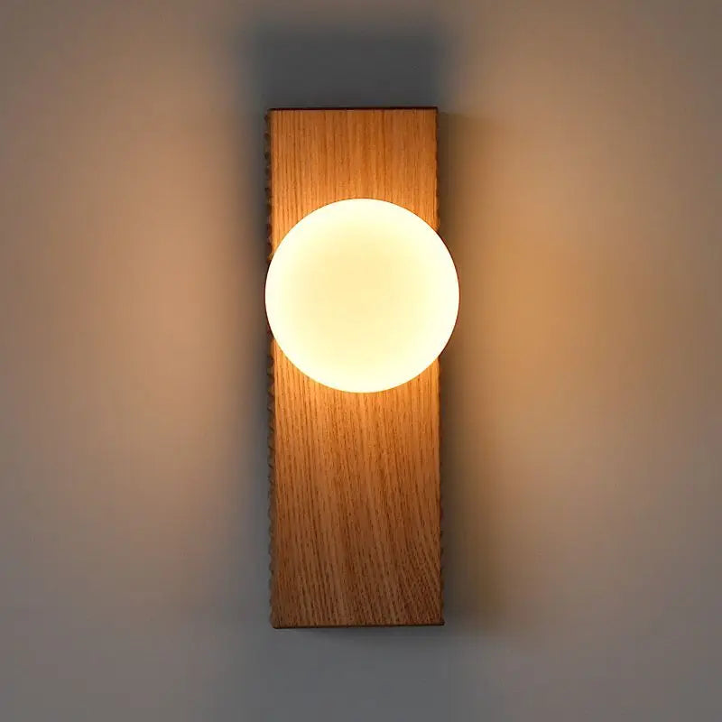 Contemporary bedroom wall lamp with glowing globe on a rectangular wood base, perfect for cozy lighting.