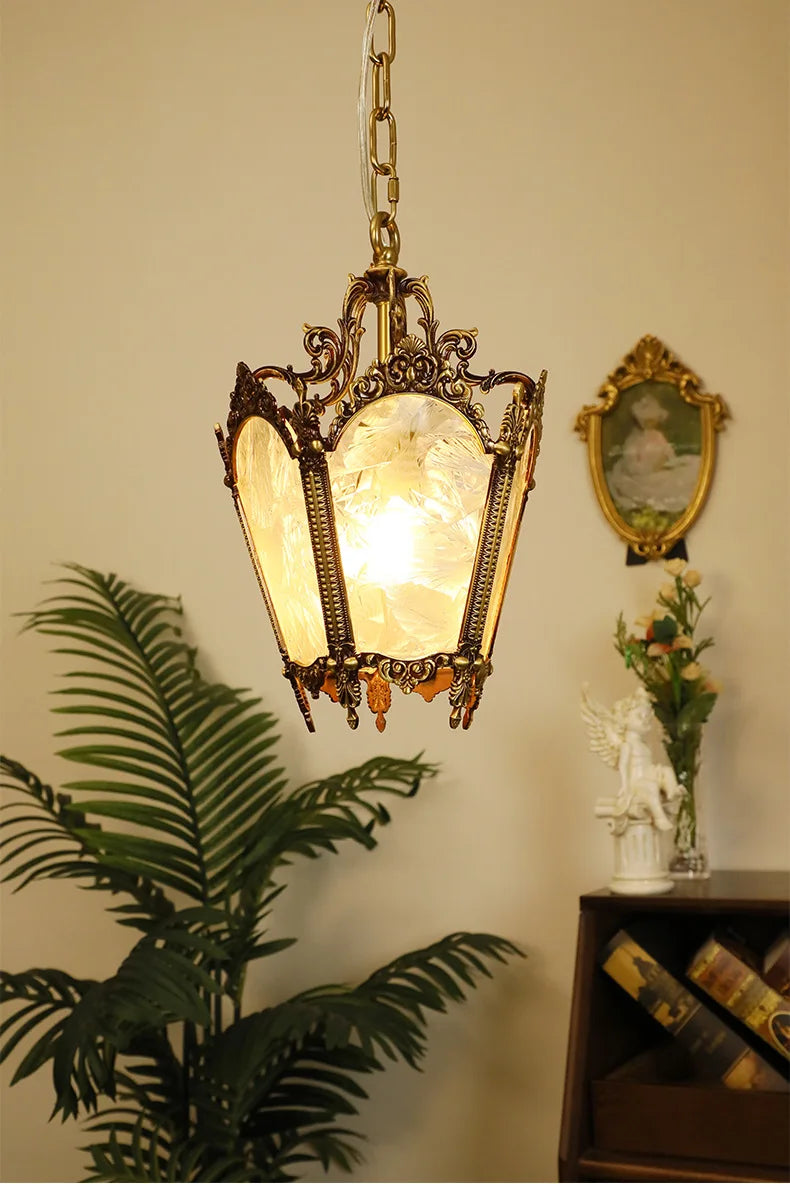 Vintage-style French glass chandelier with copper accents hanging near indoor plants. LED lighting for energy-saving elegance.