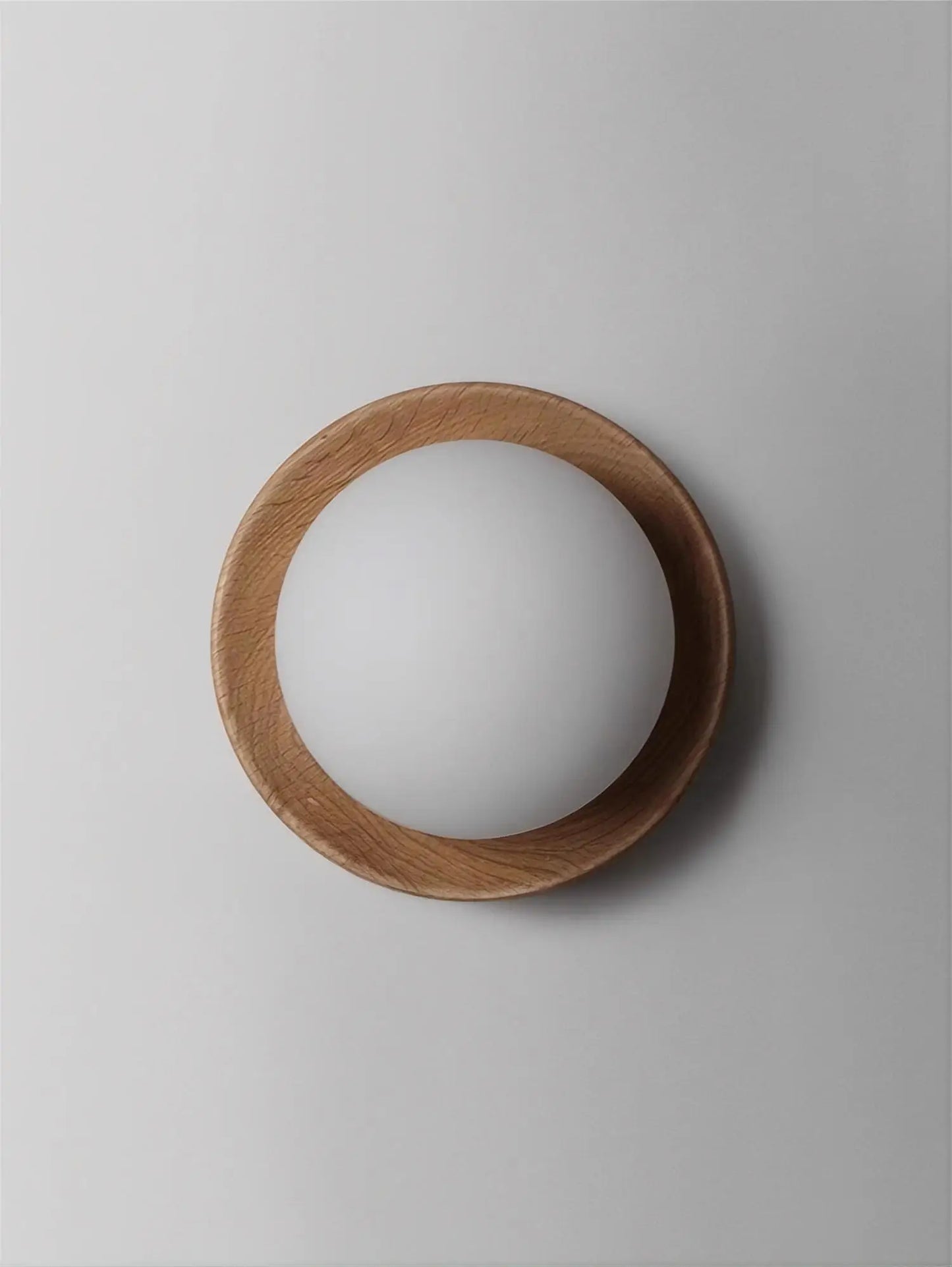 Front view of light wood wall lamp with frosted globe, ideal for modern and minimalist lighting setups.