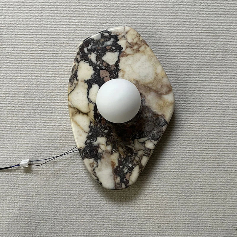 Close-up of G9 Stone Wall Light featuring a beige marble base and white glass ball sconce, ideal for stylish interior lighting.