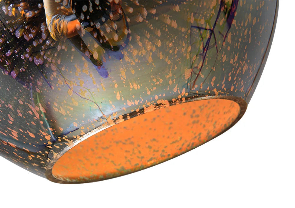 Bottom view of the glass sphere pendant light showing orange-toned inner surface and reflective fireworks 3D pattern.