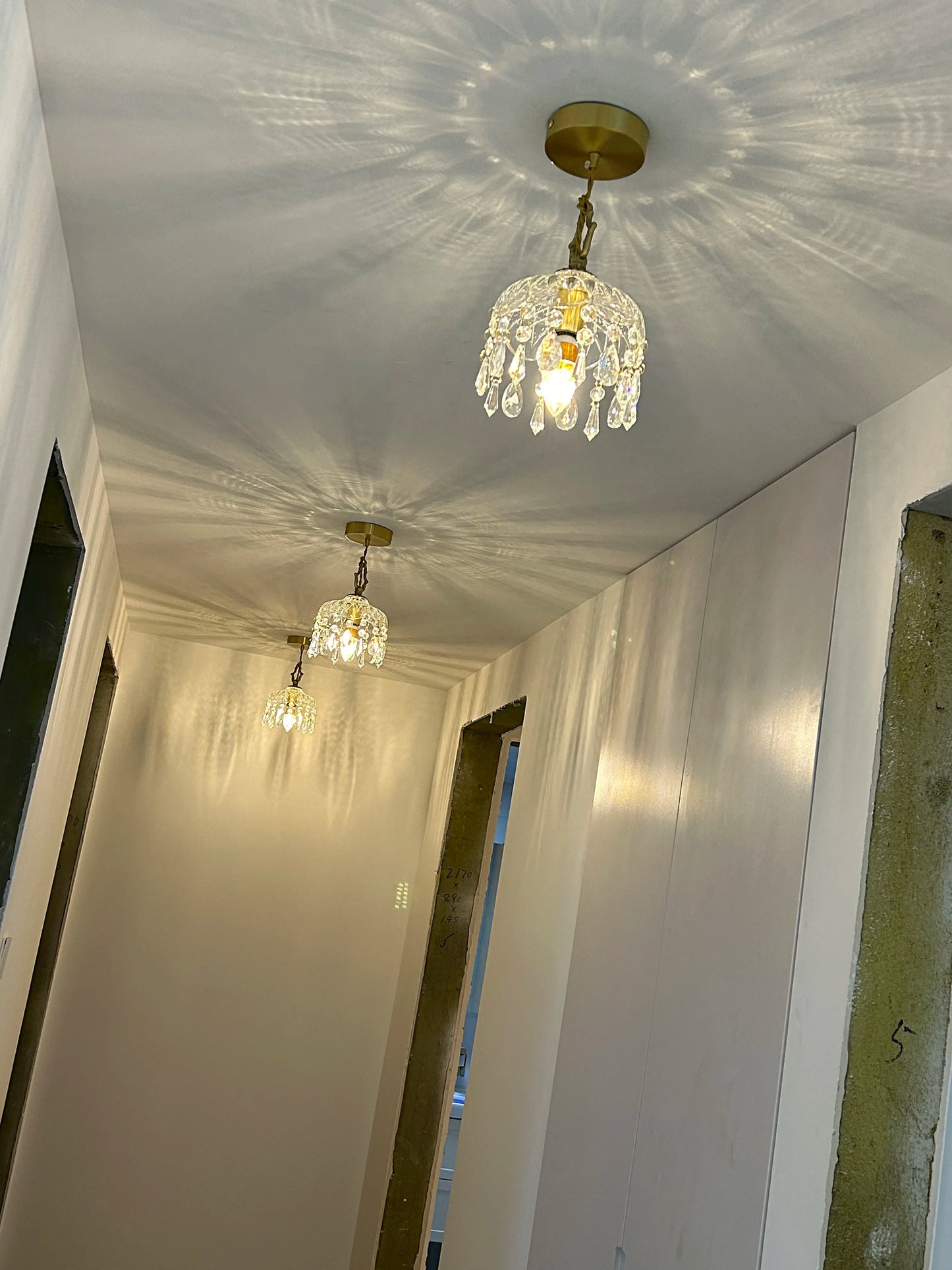 French Vintage Crystal Chandeliers - Copper Hanging Lamps in hallway, creating a luxurious and cohesive lighting design.