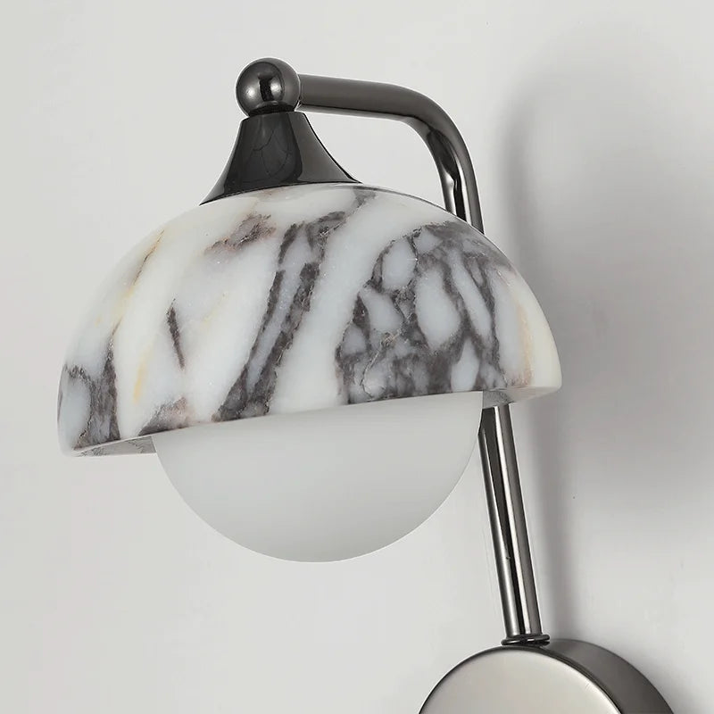 Detailed view of the alabaster wall sconce's black stone shade and frosted globe bulb, highlighting its artistic craftsmanship.