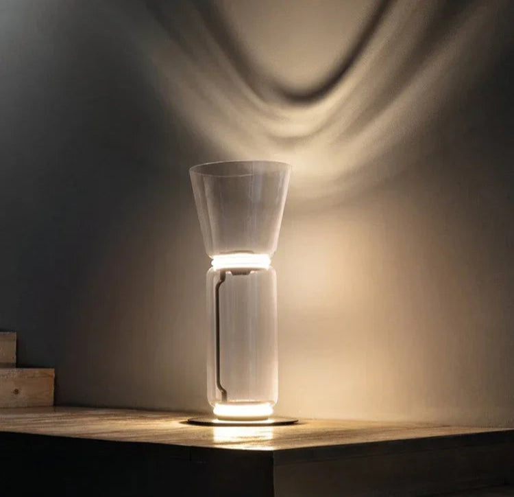 Italian minimalist glass floor lamp – nordic design with LED lighting and clear glass, casting elegant wall shadows.