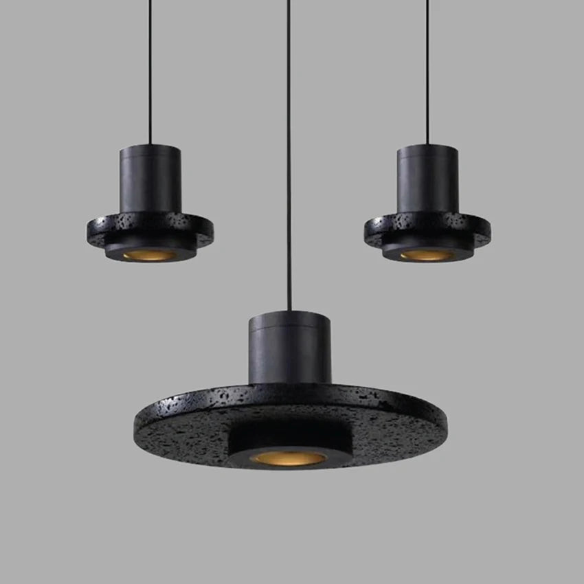 Three LUXELY industrial stone pendant lamps in varying sizes, showcasing textured black travertine finish for stylish interiors.